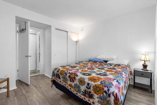 bedroom featuring a textured ceiling, a closet, and light wood-type flooring