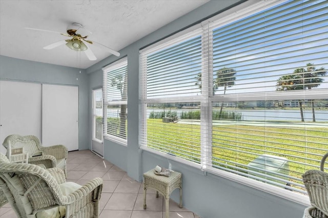 sunroom with a water view and ceiling fan