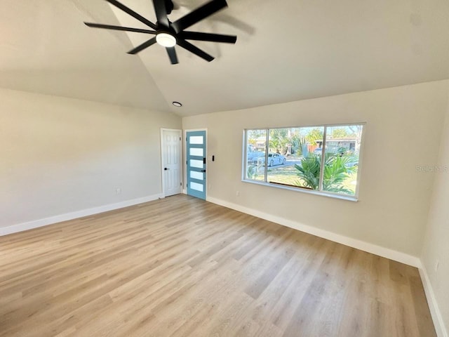 empty room with vaulted ceiling, ceiling fan, and light hardwood / wood-style floors