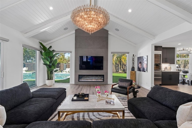 living room featuring beam ceiling, light hardwood / wood-style flooring, and a notable chandelier