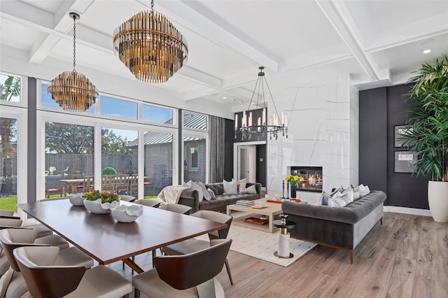 interior space featuring a tile fireplace, wood-type flooring, plenty of natural light, and a notable chandelier