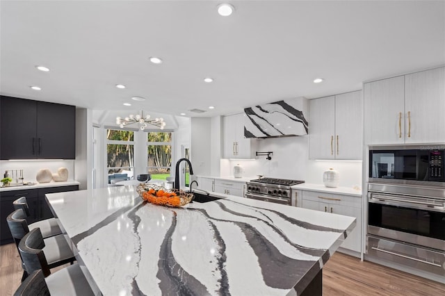 kitchen with ventilation hood, sink, a breakfast bar area, stainless steel appliances, and a spacious island