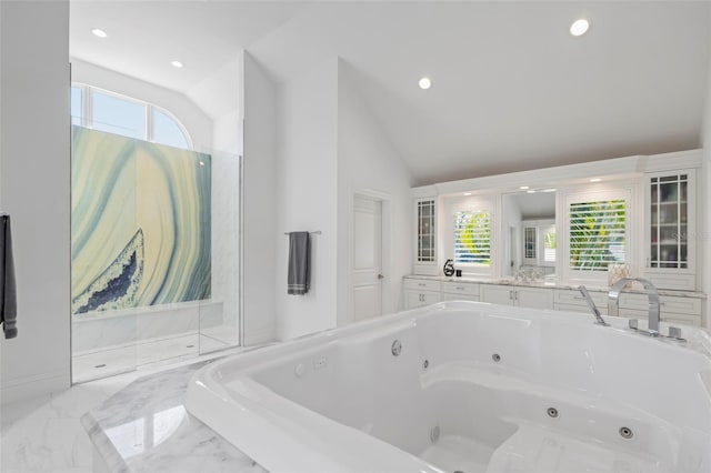 bathroom with tiled tub and vaulted ceiling