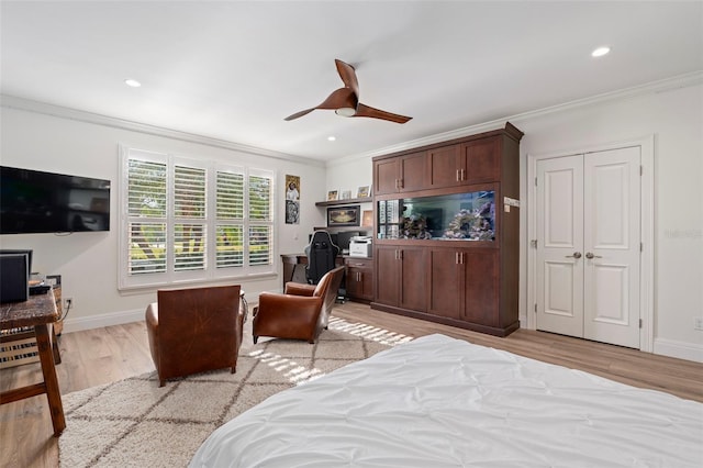 bedroom featuring ornamental molding, light hardwood / wood-style floors, and ceiling fan