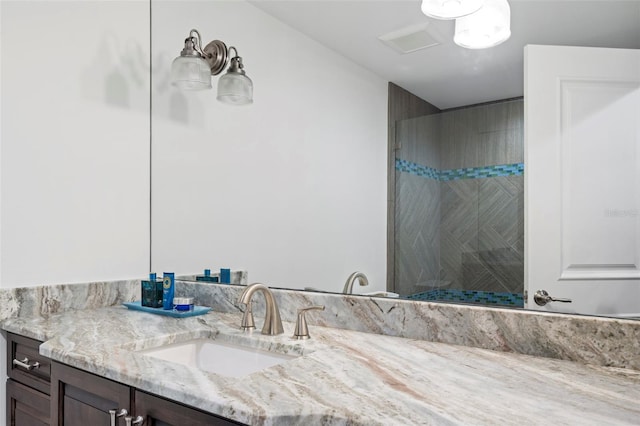 bathroom with vanity and a tile shower