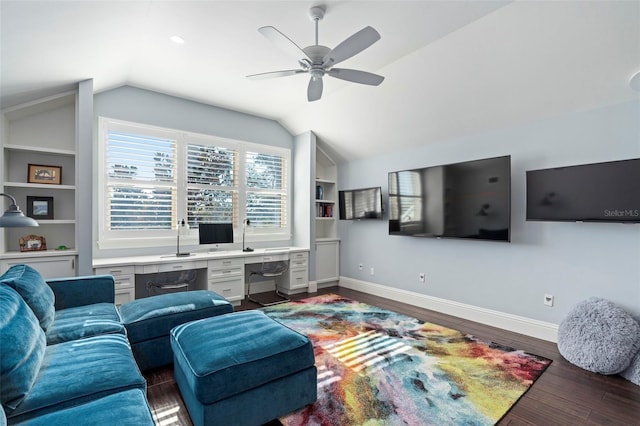 living room featuring dark wood-type flooring, ceiling fan, built in desk, built in shelves, and vaulted ceiling