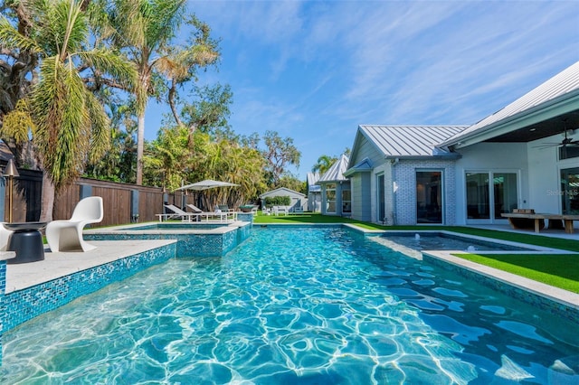 view of swimming pool with an in ground hot tub, ceiling fan, and a patio area