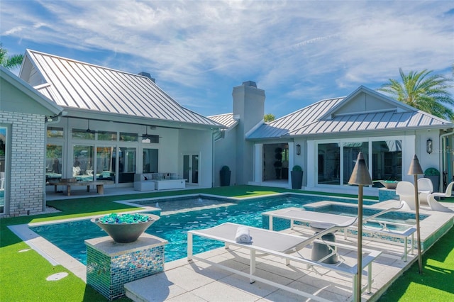 rear view of house featuring ceiling fan, a pool with hot tub, and a patio area