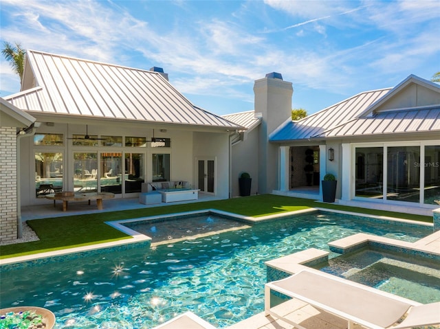 rear view of property with an outdoor hangout area, a patio area, ceiling fan, and a pool with hot tub