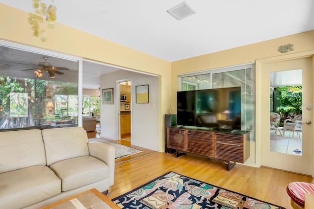 living room featuring wood-type flooring and ceiling fan