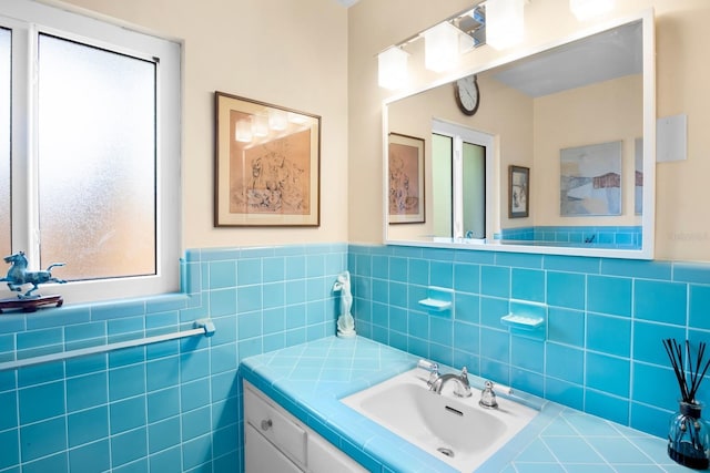 bathroom featuring vanity and tile walls