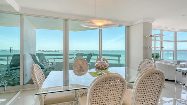 dining room with a water view and crown molding