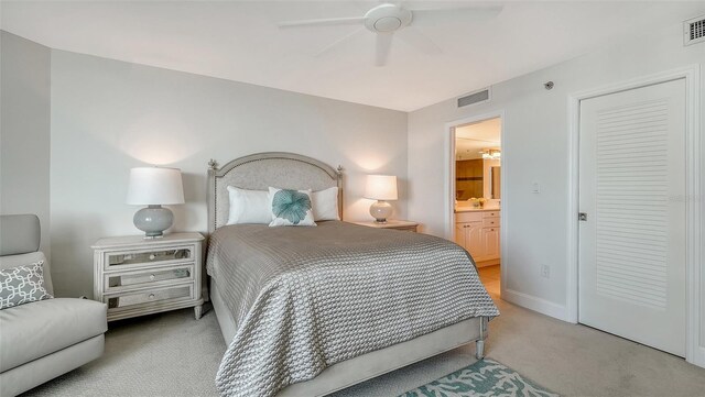 carpeted bedroom featuring ensuite bathroom, ceiling fan, visible vents, and baseboards