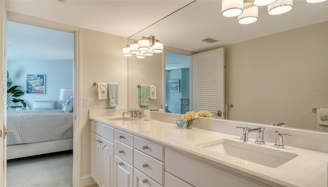 full bathroom with ensuite bathroom, double vanity, a sink, and visible vents