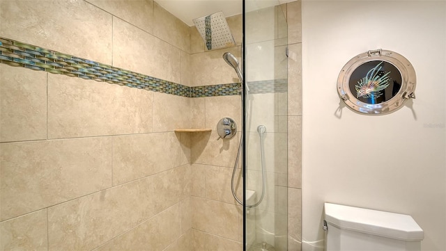 bathroom featuring tiled shower and toilet