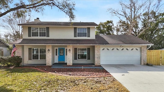 view of property featuring a garage and a front yard