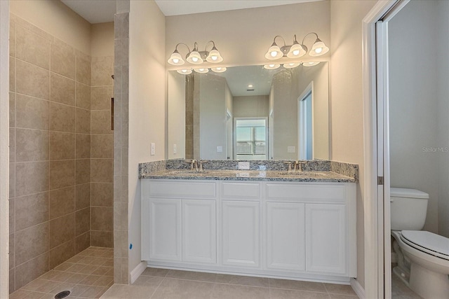 bathroom featuring tiled shower, vanity, toilet, and tile patterned floors