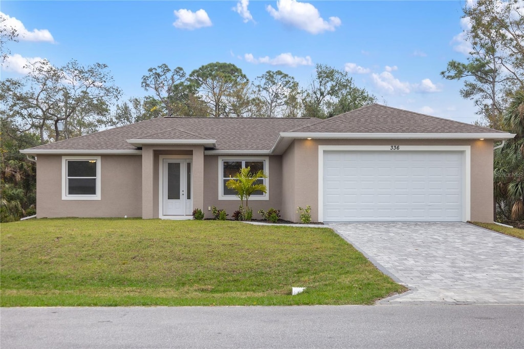 view of front of home with a garage and a front lawn