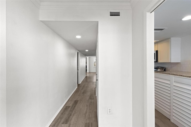 corridor with hardwood / wood-style flooring and crown molding