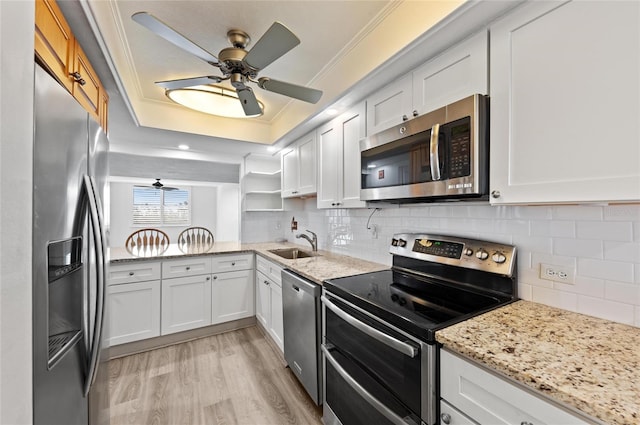 kitchen with white cabinetry, ornamental molding, appliances with stainless steel finishes, and sink