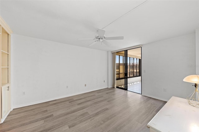 interior space with expansive windows, ceiling fan, and hardwood / wood-style floors