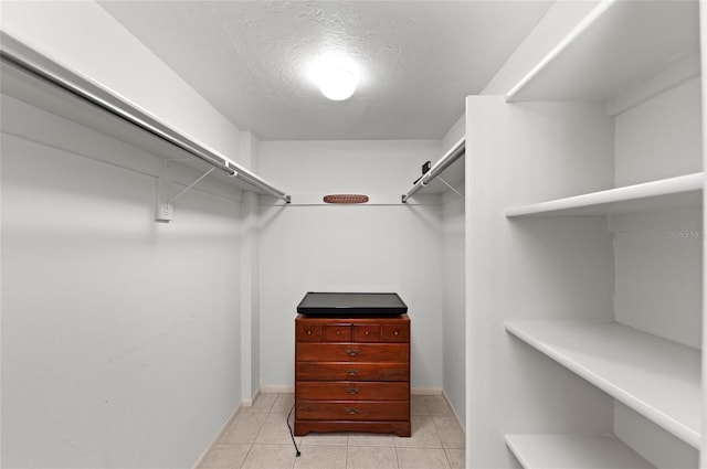 walk in closet with light tile patterned floors