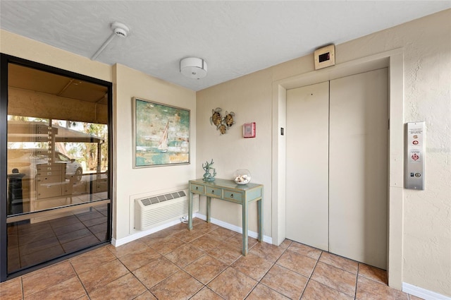 interior space featuring light tile patterned flooring, elevator, and an AC wall unit