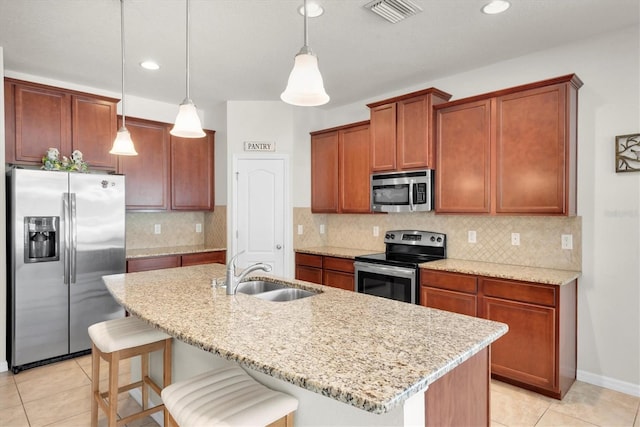5718 Broad River Run, Ellenton, FL 34222 - kitchen with stainless steel appliances, light tile patterned floors, a breakfast bar area, decorative light fixtures, and light stone counters