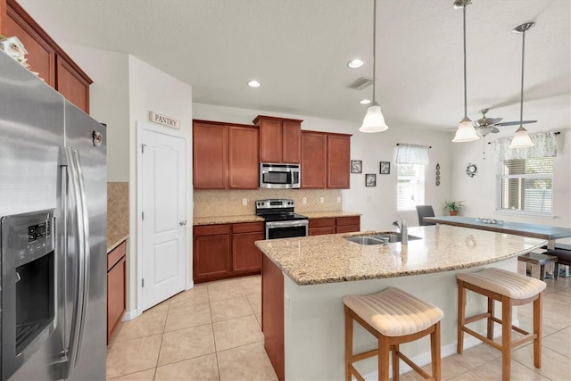 5718 Broad River Run, Ellenton, FL 34222 - kitchen featuring appliances with stainless steel finishes, decorative backsplash, a ceiling fan, a breakfast bar area, and decorative light fixtures