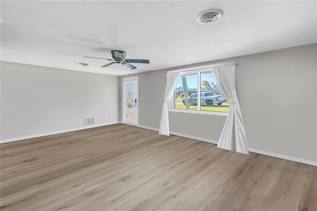 spare room featuring ceiling fan, a textured ceiling, and light wood-type flooring