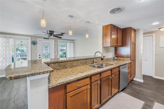 kitchen featuring sink, hanging light fixtures, stainless steel dishwasher, light stone counters, and dark wood-type flooring