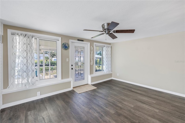 foyer entrance with dark hardwood / wood-style flooring, ceiling fan, and a textured ceiling