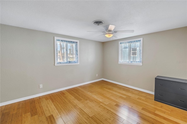 empty room featuring ceiling fan, a textured ceiling, and light hardwood / wood-style floors