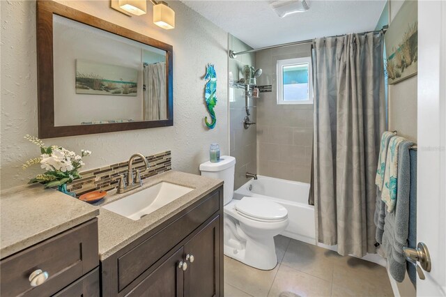 full bathroom with tile patterned flooring, vanity, tasteful backsplash, shower / bath combination with curtain, and toilet