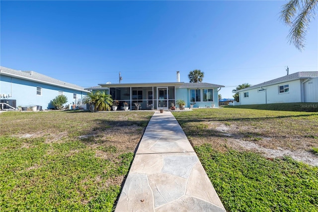 single story home featuring a sunroom and a front yard