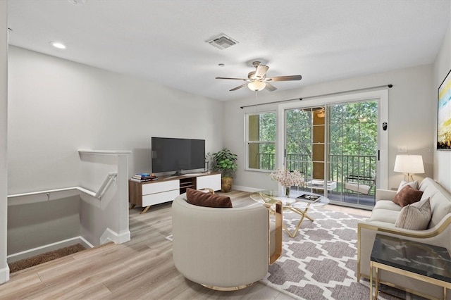 living room featuring ceiling fan and light hardwood / wood-style flooring