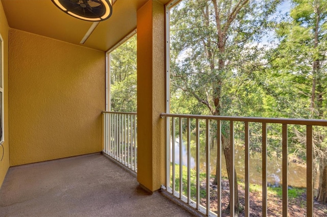 balcony with a water view and ceiling fan