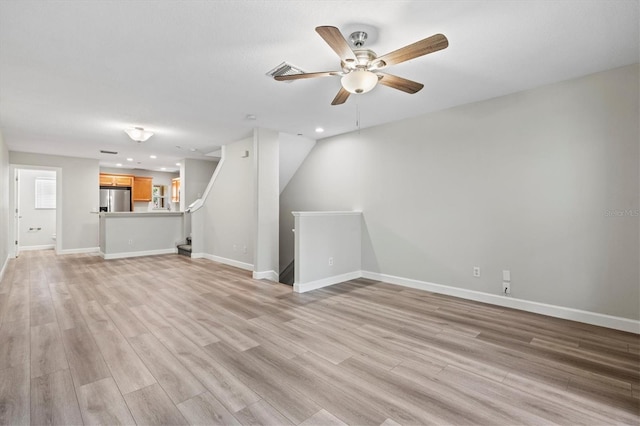 unfurnished living room with ceiling fan and light hardwood / wood-style flooring