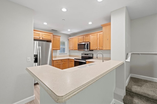 kitchen featuring appliances with stainless steel finishes, sink, light brown cabinets, and kitchen peninsula