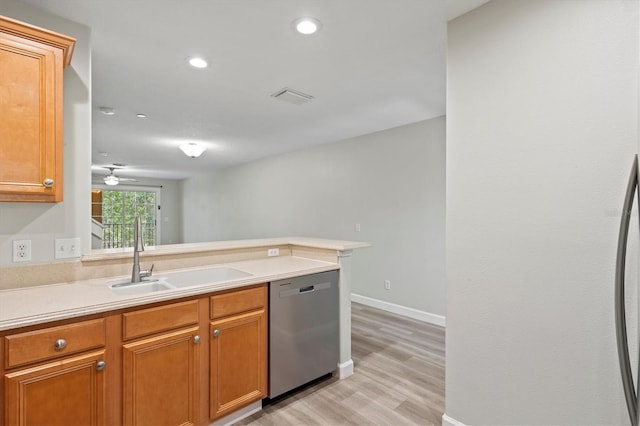 kitchen featuring stainless steel dishwasher, kitchen peninsula, sink, and light hardwood / wood-style flooring