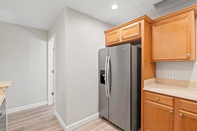 kitchen featuring stainless steel fridge with ice dispenser and light hardwood / wood-style floors