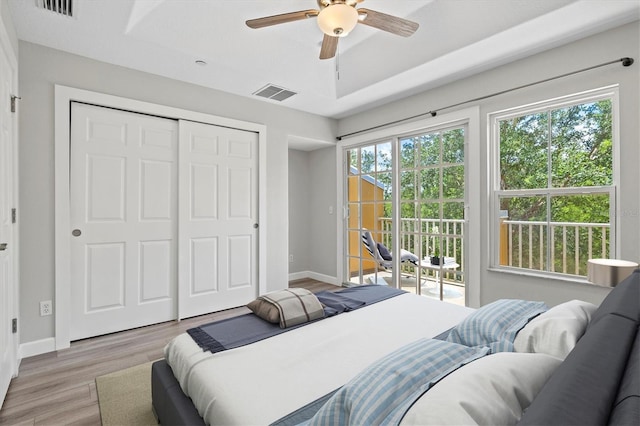 bedroom with access to exterior, light hardwood / wood-style floors, a closet, and ceiling fan