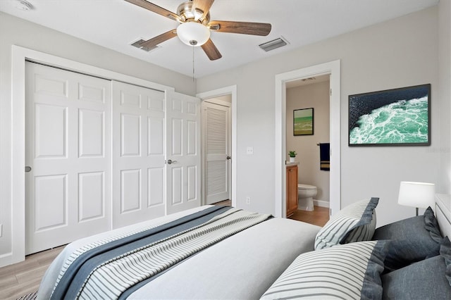 bedroom with ceiling fan, ensuite bathroom, a closet, and light wood-type flooring