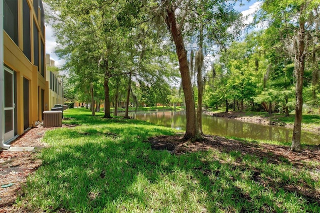 view of yard featuring a water view and central AC unit