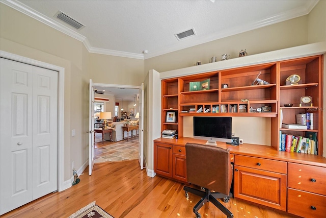 home office with ornamental molding and light hardwood / wood-style floors