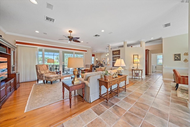 living room with a wealth of natural light, ornamental molding, and decorative columns