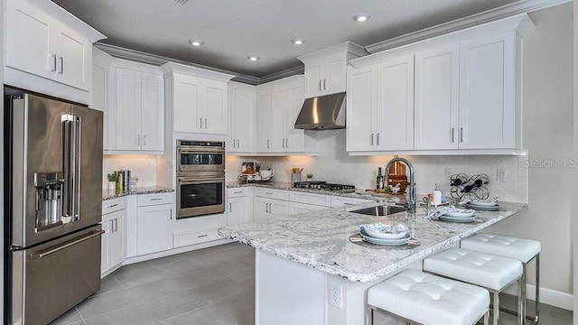 kitchen featuring appliances with stainless steel finishes, sink, a breakfast bar area, and white cabinets