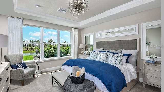 carpeted bedroom with a water view, a tray ceiling, a textured ceiling, and crown molding