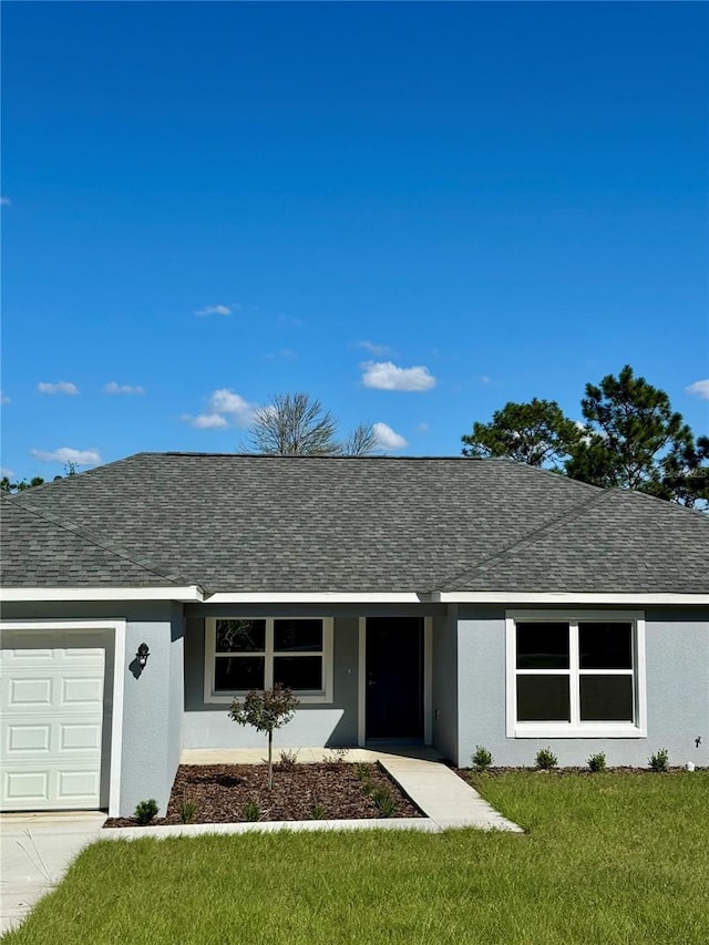 ranch-style house with a garage and a front lawn