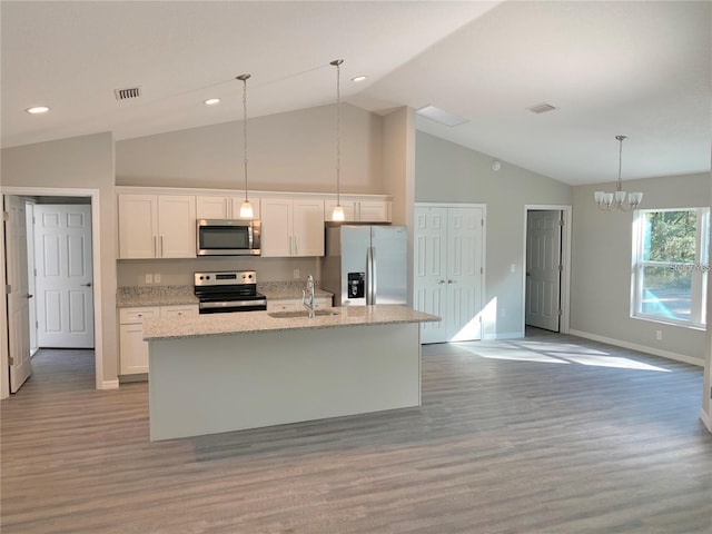 kitchen with an island with sink, sink, white cabinets, stainless steel appliances, and light hardwood / wood-style flooring